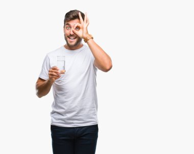 Yakışıklı delikanlı ile mutlu yüz el parmaklarının arasından seyir göz üzerinde ok işaretiyle yapıyor gülümseyen izole arka plan üzerinde bardak su içme