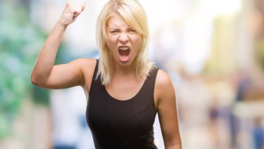 Zarif giyen genç güzel sarışın çekici kadın giysi izole arka plan öfkeli ve sinirli sinirli ve öfke ile bağırarak süre öfkeli yumruk yükselterek üzerinde. Öfke ve agresif kavramı.