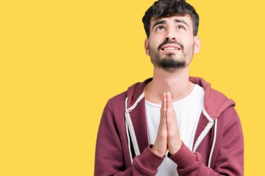 Yakışıklı delikanlı yalvarıyor ve umut ifade yüzünde çok duygusal ve endişe ile birlikte elleriyle dua izole arka plan üzerinde. Bağışlanmak. Din kavramı.