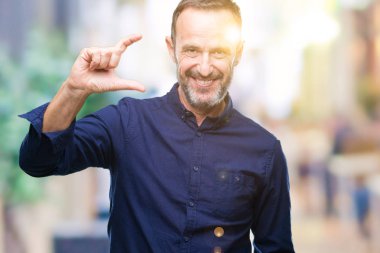 Orta yaş üzerinde gülümseyen izole arka plan ve süre seyir ve kamera boyutu işaret parmaklarıyla yapıyor el ile kendine güvenen el hareketi ağarmış komuta sizde. Ölçü kavramı.