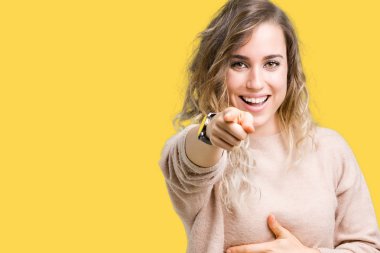 Güzel sarışın genç kadın giyen sweatershirt izole üzerinde arka plan sizin parmak el kamerasıyla göğüs üzerinde utanç ifadesi işaret eden gülme
