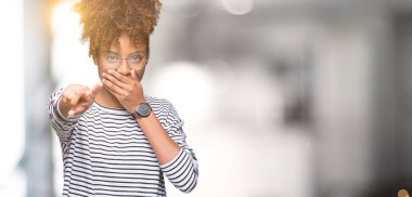 Güzel genç Afro-Amerikan kadın gözlük izole üzerinde gülme sizin parmak el kamerasıyla ağzına, utanç ifadesi işaret eden arka plan