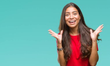 Genç güzel Arap kadın deli kutluyor ve silah ile başarı için heyecanlı çığlık kaldırdı ve açık gözleri hayret izole arka plan yüzünden. Kazanan kavramı