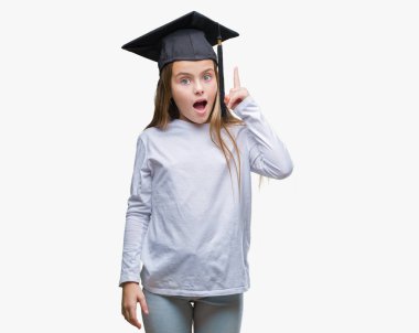 Başarılı fikirle izole arka plan işaret parmağı lisansüstü kap giyen genç güzel kız. Çıktıktan ve mutlu. Bir numara.