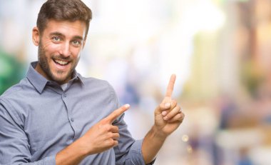 Yakışıklı delikanlı gülümseyen ve iki elleri ve parmakları ile tarafına işaret kamera bakarak izole arka plan üzerinde.