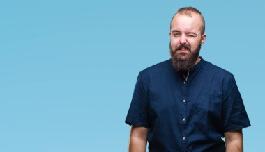 Genç beyaz hipster adam seksi bir ifadeyle, neşeli ve mutlu yüzünü kameraya bakarak göz kırpıyor izole arka plan.