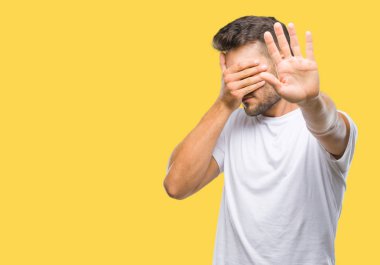 Genç yakışıklı adam izole elleriyle gözlerini kapsayan arka plan ve stop jest ile acı ve korku ifadesi. Utandım ve negatif kavramı.