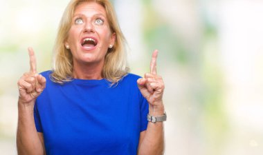 Orta yaş sarışın kadın izole arka plan üzerinden hayran ve yukarıya bakıp parmakları ile işaret şaşırttı ve silah kaldırdı.