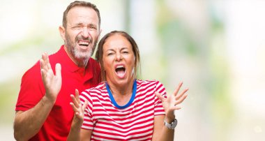 Orta yaş İspanyol çift izole arka plan çılgın ve kızgın bağırarak ve agresif ifade ve silah kaldırdı bağırmaya aşık. Hayal kırıklığı kavramı.