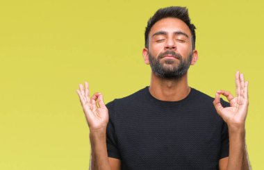 İzole arka plan yetişkin İspanyol adam rahatla ve gülümseyen gözlerle kapalı parmak jestle meditasyon yapıyor. Yoga kavramı.