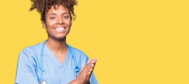 Genç Afro-Amerikan doktor kadın izole arka plan Clapping ve mutlu ve neşeli, gururlu gülümseyen birlikte eller alkış