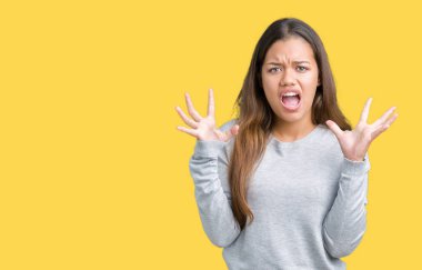 Üzerinde kazak giyen genç güzel esmer kadın deli kutluyor arka plan izole ve silah ile başarı için yükseltilmiş ve açık gözleri heyecanlı çığlık hayrete düşürdü. Kazanan kavramı