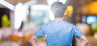 Genç doktor yalıtılmış arka plan ayakta geriye doğru uzakta silah ile vücut üzerinde seyir üzerinde tıbbi üniforma