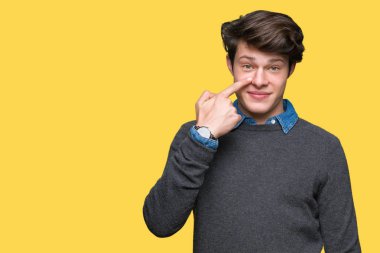 Genç yakışıklı zarif adam izole üzerinde arka plan işaretçi el parmak yüz ve burun, neşeli gülümseyen