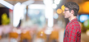 Genç yakışıklı öğrenci adam gözlük izole arka tarafına, seyir üzerinde dinlenmek doğal yüz emin gülümseme ile pozuyla profili.