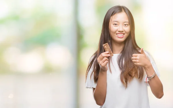 Joven Mujer Asiática Comiendo Chocolate Enérgico Bar Sobre Aislado Fondo — Foto de Stock