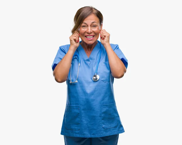 中年资深护士医生妇女在被隔绝的背景覆盖耳朵用手指以恼怒的表示为大声的音乐噪声 聋的概念 — 图库照片