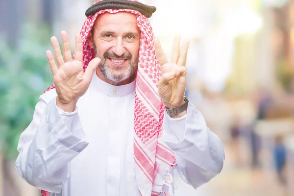シニアのアラブ人にクーフィーヤを着て分離を示す背景と数 ながら自信を持って 幸せな笑みを浮かべて指で上向き — ストック写真
