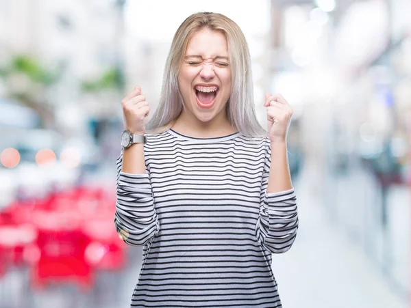 年轻的金发女人在孤立的背景下兴奋的成功与手臂举起庆祝胜利微笑 赢家理念 — 图库照片