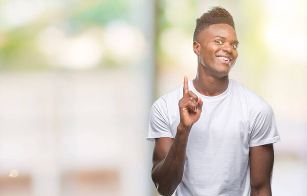 Young african american man over isolated background pointing finger up with successful idea. Exited and happy. Number one.