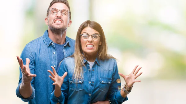 年轻夫妇在爱戴眼镜在孤立的背景疯狂和疯狂的呼喊和尖叫与积极的表达和武器提出 挫折概念 — 图库照片