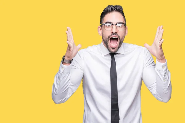 stock image Young handsome business man wearing glasses over isolated background celebrating crazy and amazed for success with arms raised and open eyes screaming excited. Winner concept