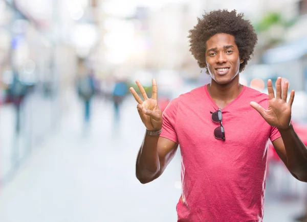 Afro american man over isolated background showing and pointing up with fingers number eight while smiling confident and happy.