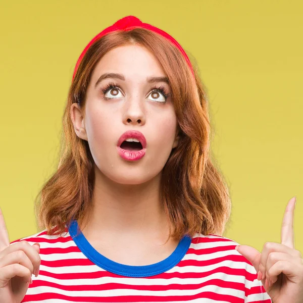 Genç güzel kadın izole arka plan üzerinden hayran ve yukarıya bakıp parmakları ile işaret şaşırttı ve silah kaldırdı.