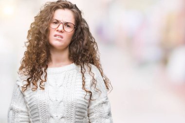 Güzel esmer kıvırcık saçlı Genç kız sorunu nedeniyle izole arka plan şüpheci ve sinir, papatyanın üzgün üzerinde kış kazak giyiyor. Negatif kişi.