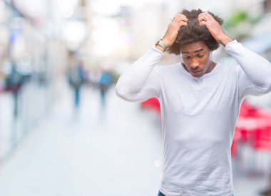 Afro Amerikalı adam çünkü umutsuz ve stresli baş ağrısı acı izole arka plan üzerinde ağrı ve migren. Ellerini kafasına.