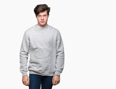 Üzerinde sweatshirt giyen genç yakışıklı sportif adam arka plan gevşek yüzünde ciddi bir ifade ile izole. Basit ve doğal kameraya bakıyor.