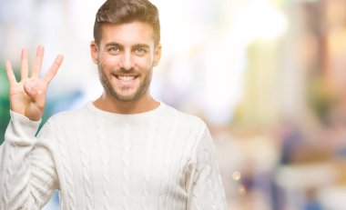 Gösterilen arka plan üzerinde kış kazak giyen genç yakışıklı adam izole ve parmakları ile işaret kendinden emin ve mutlu gülümseyerek süre dört numara.