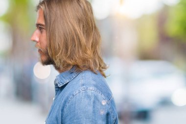 İzole arka tarafına, seyir üzerinde uzun saçlı Genç yakışıklı adam sakin ol kendine güvenen gülümseme ile doğal yüz pozuyla profili.