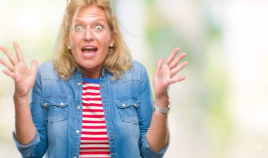 Orta yaş sarışın kadın deli kutluyor arka plan izole ve başarı için kaldırdı kollarını açarak hayrete ve heyecanlı çığlık gözleri açık. Kazanan kavramı