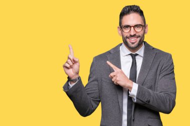 Genç yakışıklı iş adamı gülümseyen ve iki elleri ve parmakları ile tarafına işaret kamera bakarak izole arka plan üzerinde.