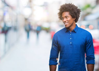 Uzak tarafına yüzünde, doğal ifade gülümseme ile seyir izole arka plan üzerinde Afro Amerikalı adam. Kendine güvenen gülüyor.