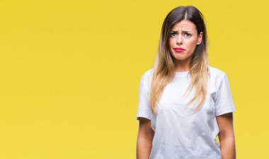 Genç güzel kadın sorunu nedeniyle çatık casual beyaz t-shirt üzerinde izole arka plan şüpheci ve sinir, üzgün. Negatif kişi.