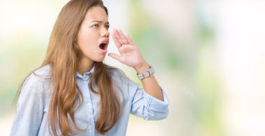 Genç güzel esmer iş kadını bağırarak ve ağzı üzerinde el ile yan için çığlık izole arka plan üzerinde. İletişim kavramı.