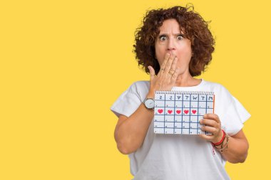 Hata, korku, sessizlik içinde gizli kavramı korkmuş ifade için utanç ile izole arka kapak ağız el ile üzerinden adet takvim tutan orta ager üst düzey kadın şok