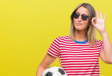 Parmak, mükemmel sembolü ile ok işareti yapıyor izole arka plan üzerinde futbol futbol topu tutan genç güzel kadın