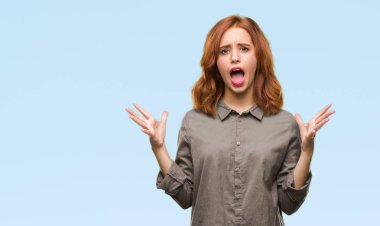 Genç güzel kadın deli kutluyor ve silah ile başarı için heyecanlı çığlık kaldırdı ve açık gözleri hayret izole arka plan yüzünden. Kazanan kavramı