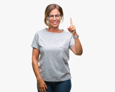 Başarılı fikirle izole arka plan işaret parmağı üzerinde gözlük takan orta yaş İspanyol kadın kıdemli. Çıktıktan ve mutlu. Bir numara.