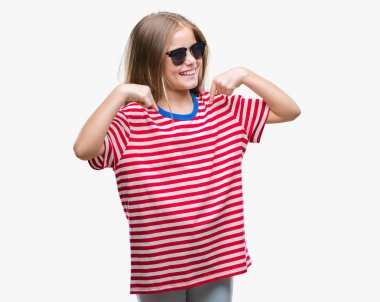 Yüzünde gülümseme ile kendinden emin görünüyorsun, kendini gururlu ve mutlu parmakları ile işaret izole arka plan üzerinde güneş gözlüğü takmış genç güzel kız.