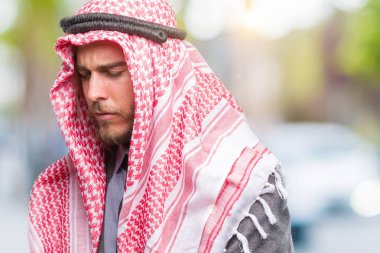 Genç yakışıklı Arap adam uzun saçlı keffiyeh üzerinde giyen izole mide üzerinde el ile arka plan çünkü mide bulantısı, ağrılı hastalık hasta hissediyor. Ağrısı kavramı.