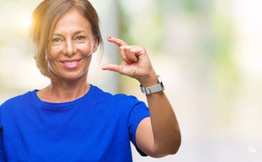 Orta yaş İspanyol kadın kıdemli izole arka plan gülümseyen ve süre seyir ve kamera boyutu işaret parmaklarıyla yapıyor el ile kendinden emin eller üzerinde. Ölçü kavramı.