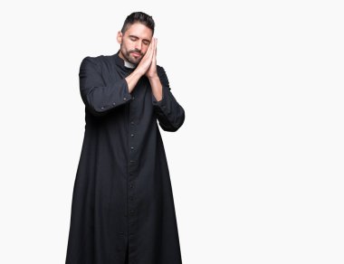 Genç Hıristiyan rahip uyku yorgun hayal ve ellerle birlikte poz ile kapalı gözler gülümseyen izole arka plan üzerinde.