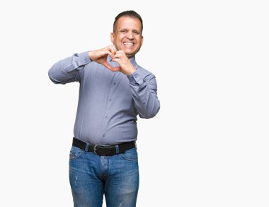 Orta yaş Arap iş adamı aşık kalp simgesi ve elleriyle şekil gösteren gülümseyen izole arka plan üzerinde. Romantik kavramı.