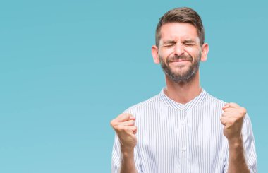 Soyutlanmış, mutlu ve heyecanlı genç bir adam kollarını kaldırmış, gülümseyen ve başarı için çığlık atan kazanan bir jest yapıyor. Kutlama konsepti.