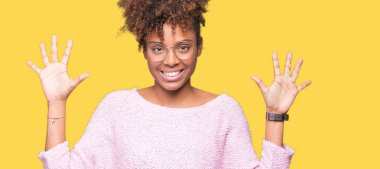 Güzel genç Afro-Amerikan kadın gözlük gösterilen ve parmakları ile işaret izole arka plan üzerinde number ten kendinden emin ve mutlu gülümseyerek süre.