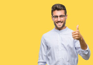 Yakışıklı delikanlı hareketi el ile mutlu yaşasın yapıyor izole arka plan üzerinde. Kameraya bakarak başarı gösteren ile ifade onaylama.